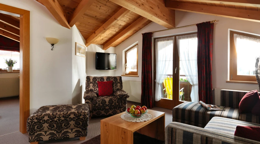 Apartment Alpina, Alpina Serfaus, Sofabereich mit Blick auf den TV und Zugang zum Balkon.