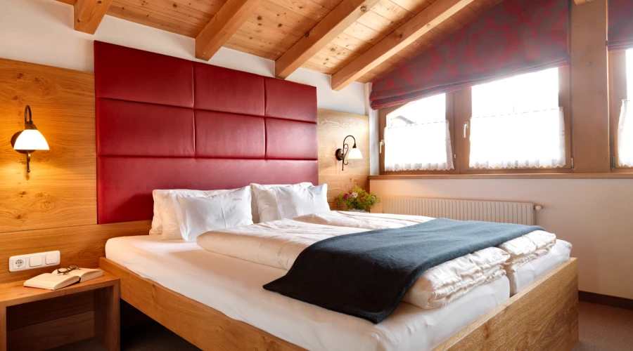 Apartment Alpina, Alpina Serfaus, großes Doppelbett direkt unter dem Dach mit großen Fenstern und wunderschöner Aussicht.